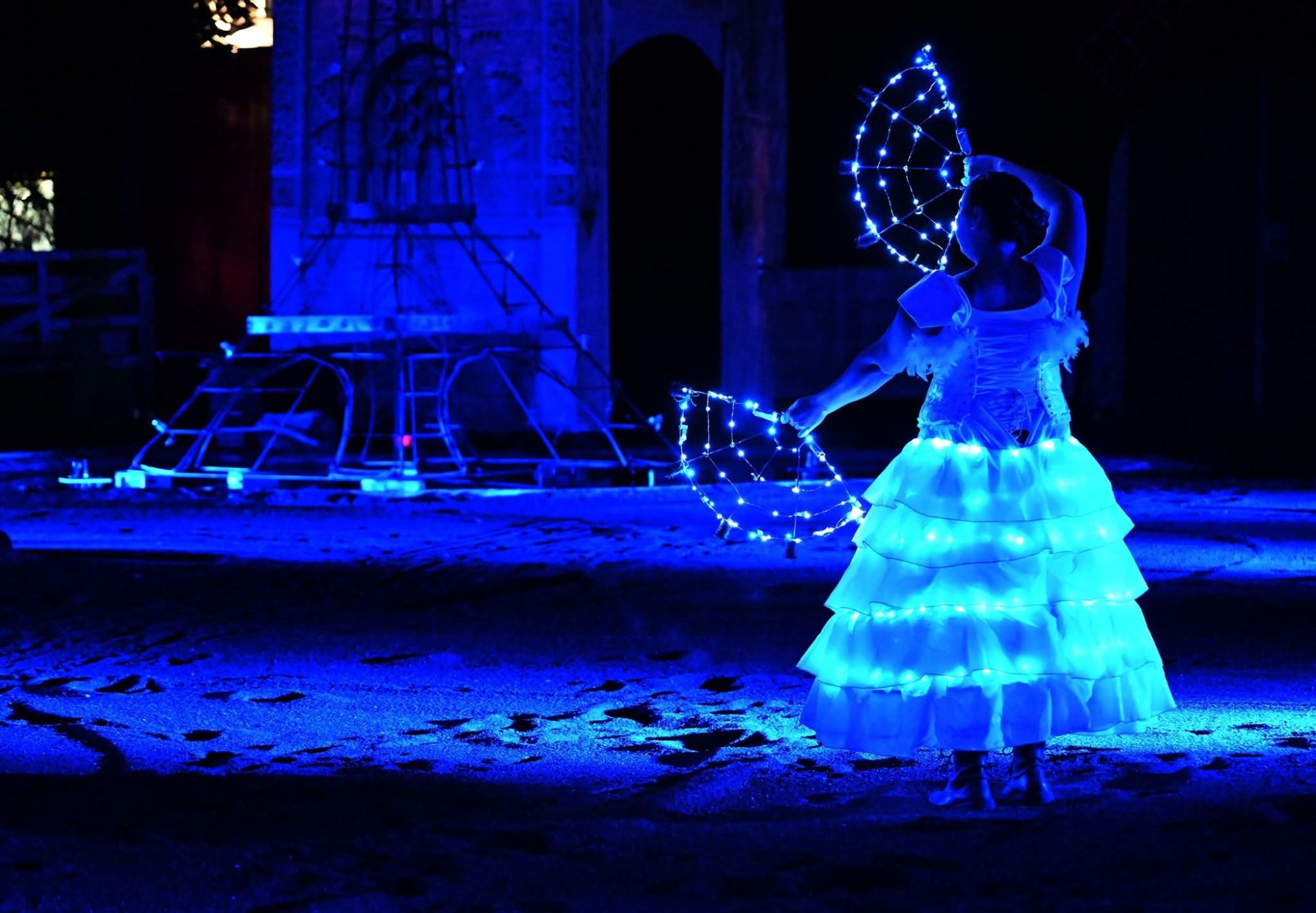 On y voit une femme dans la nuit avec une robe toute illuminée de Led