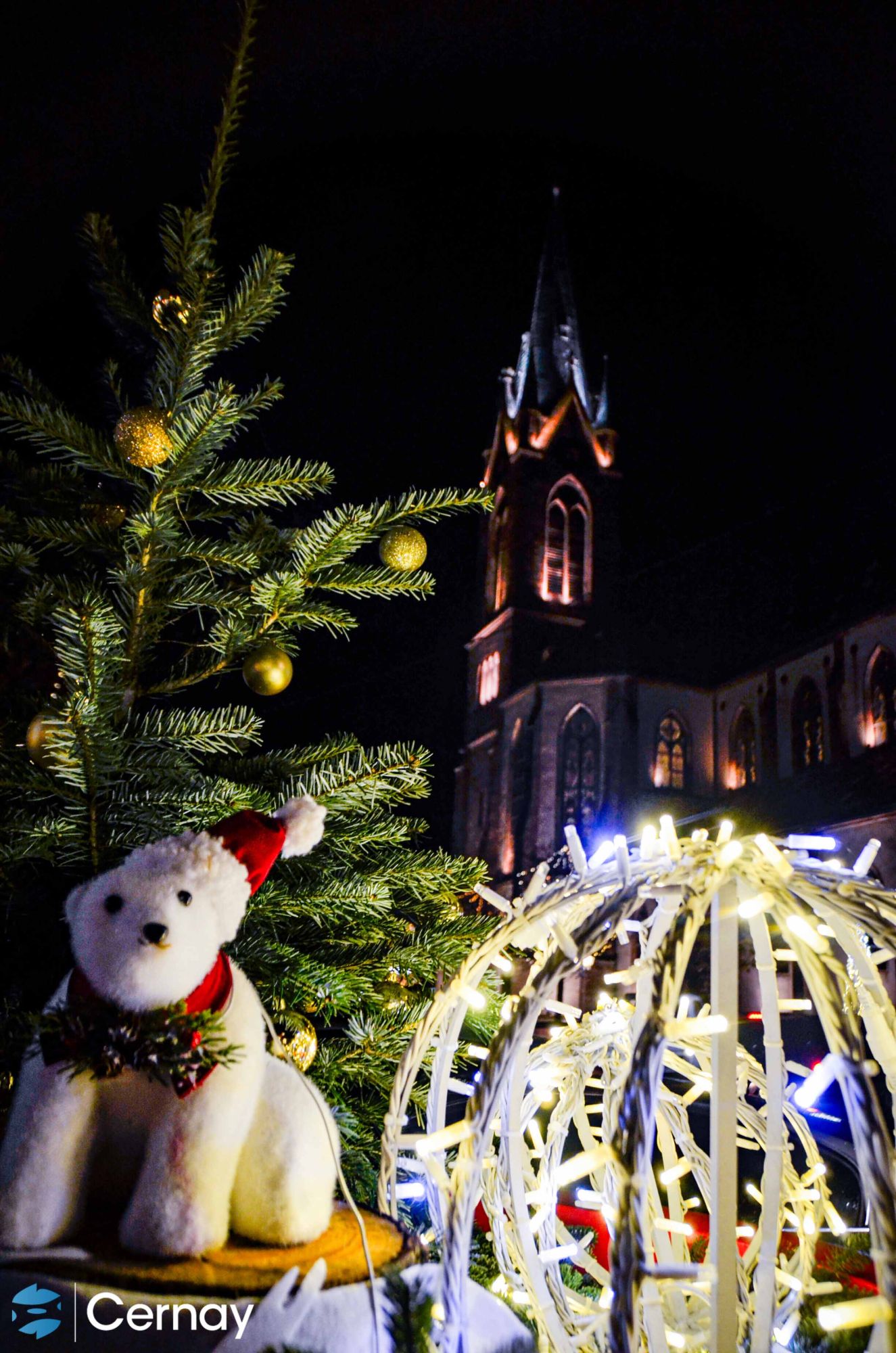 On y voit des décorations de Noël, un ours polaire blanc avec un bonnet rouger et une grande boule lumineuse