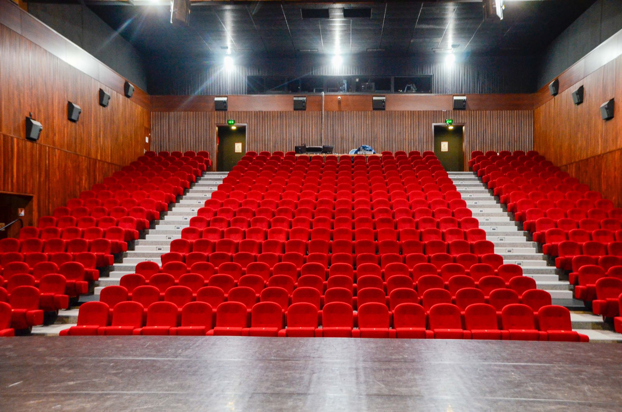 Photo de la salle de spectacle de l'Espace Gr&uuml;n avec ses fauteuils rouge et sa sc&egrave;ne